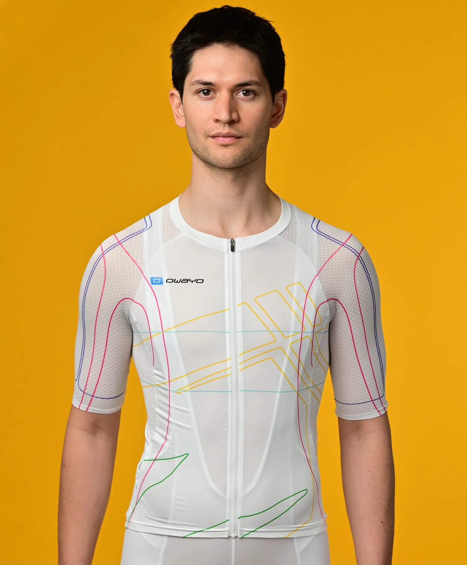 Un uomo indossa una maglia sportiva bianca a maniche corte con linee colorate di owayo su uno sfondo giallo.